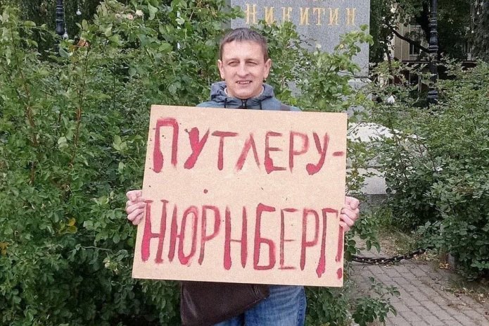 <em>Григорий Северин в одиночном пикете. За этот же плакат в январе 2021 года его <a href="https://zmeeyejg---mekodxpr-bsccljbcrq-ez.a.run.app/express-news/2021/01/20/voronezhca-arestovali-iz-za-odinochnogo-piketa-v-podderzhku-navalnogo"><u>арестовали</u></a> на пять суток (ч. 8 ст. 20.2 КоАП РФ) / Фото: Свободные Люди Воронежа</em>